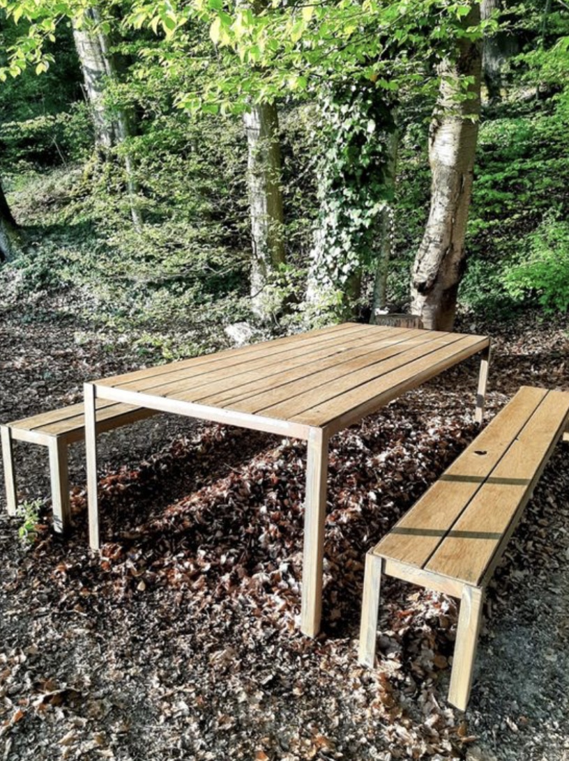 Geliefertes Gartenmobiliar aus Holz und Stahl im Wald