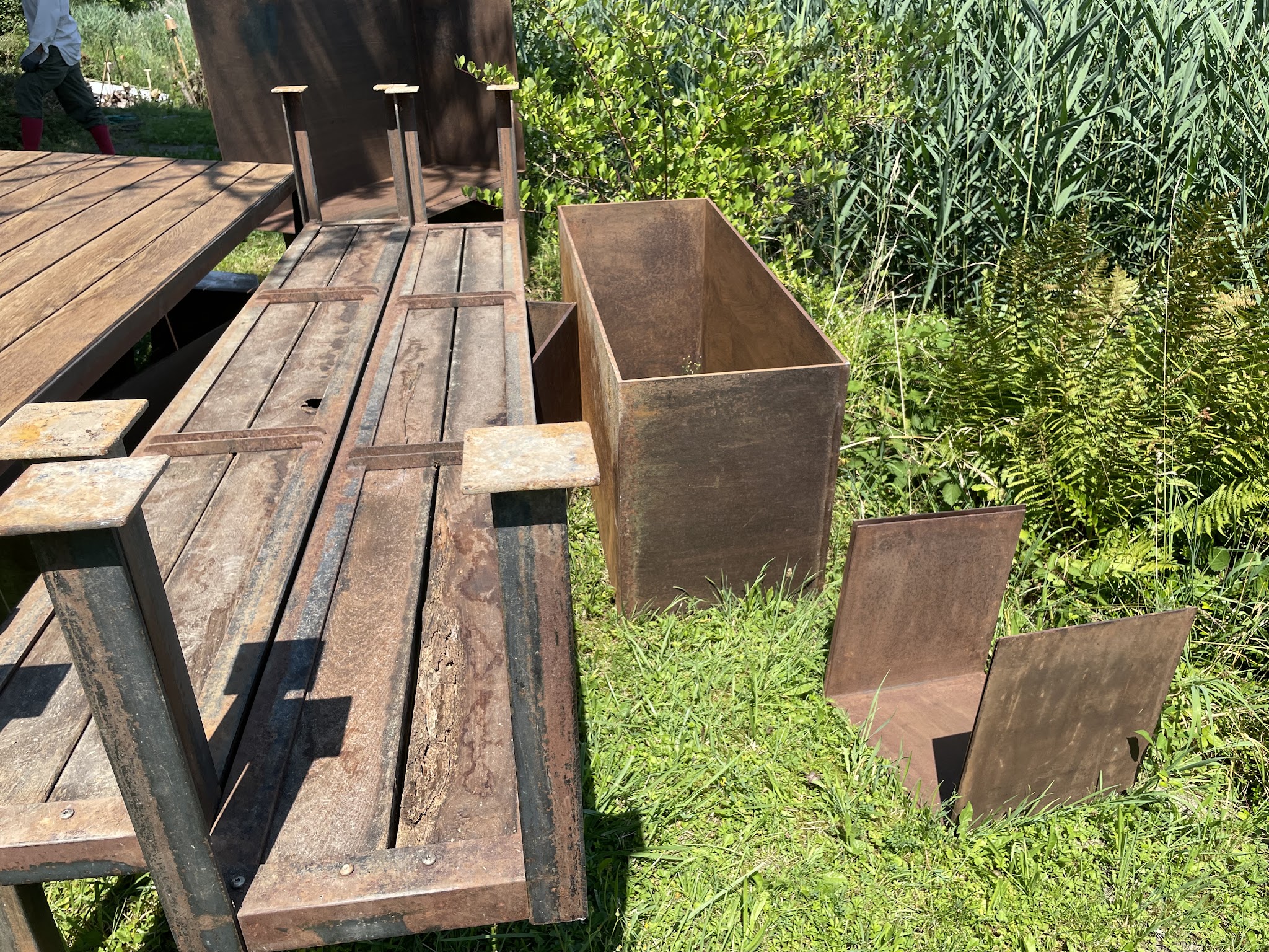 Gelieferter Gartentisch aus verwittertem Stahl und Holz mit Pflanzkisten